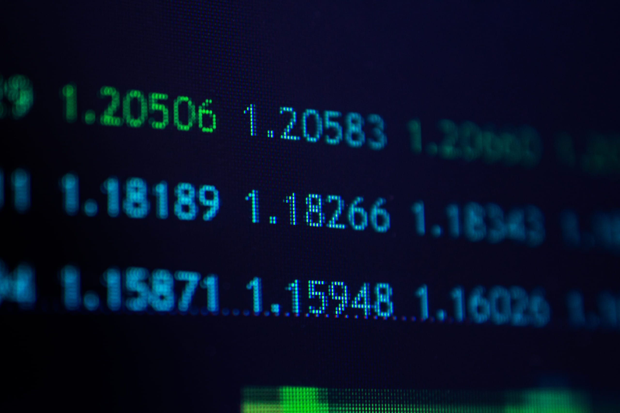 Rows of five-decimal quotes such as 1.20506 and 1.18189 glowing green and blue on a dark screen.